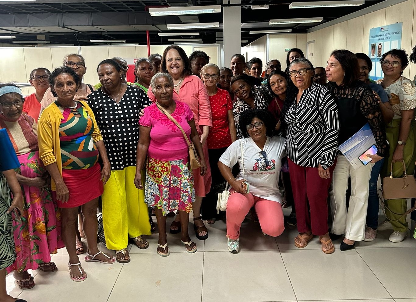 Grupo de mulheres com vestes casuais, em pé lado a lado, algumas agachadas