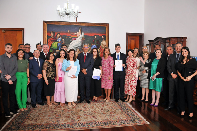 Foto colorida horizontal posada de homens e mulheres em pé, no Gabinete da Presidência do TJMA, durante posse de juízes e juíza.