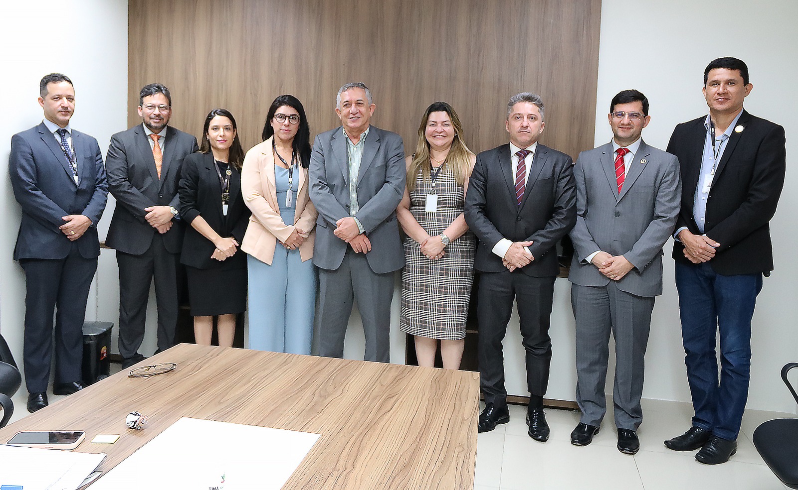 Foto colorida de homens e mulheres em pé durante reunião da Comissão de Segurança do TJMA.