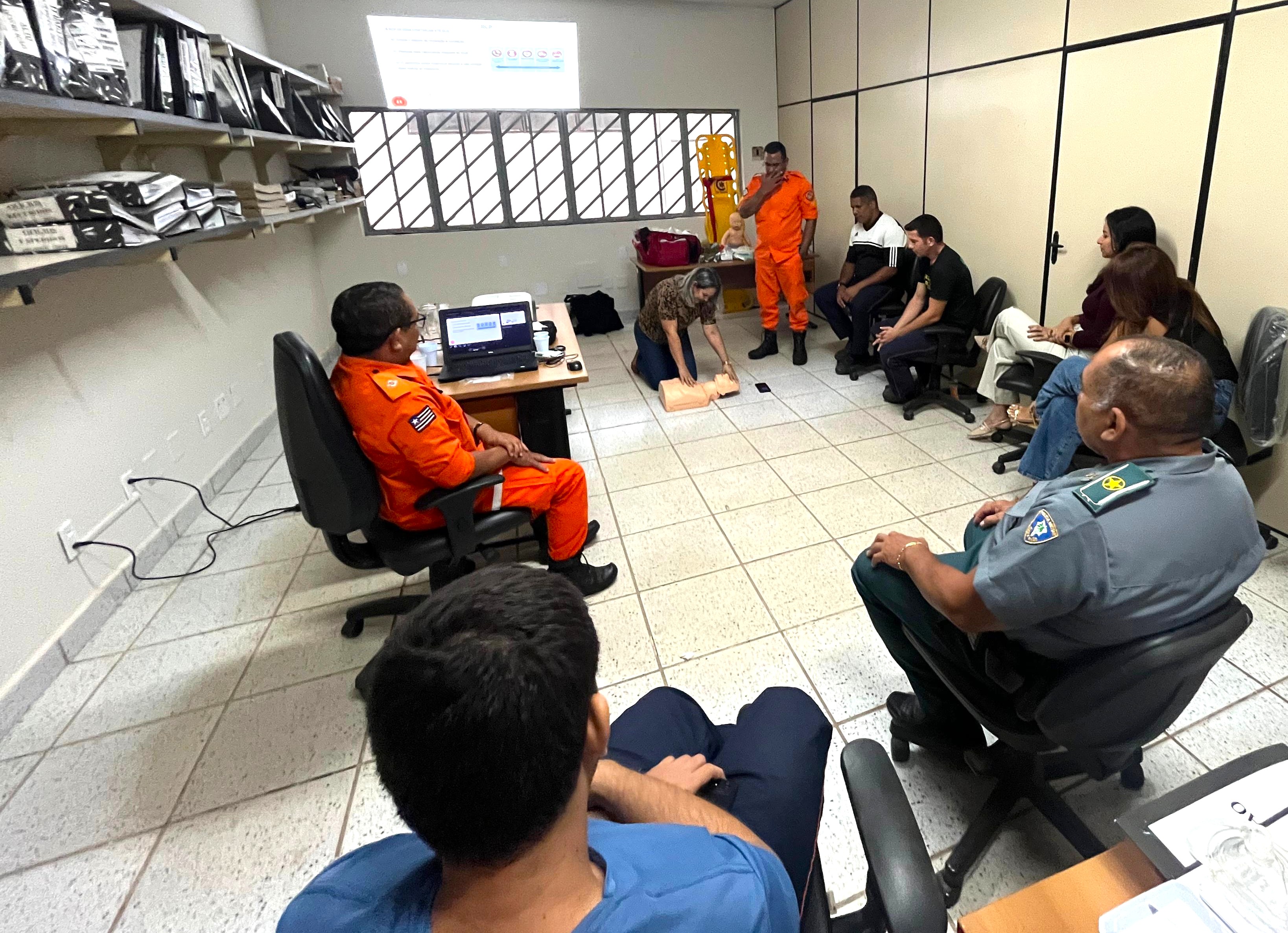 Foto colorida mostra várias pessoas em pé e agachadas durante formação de Brigada de Incêndio