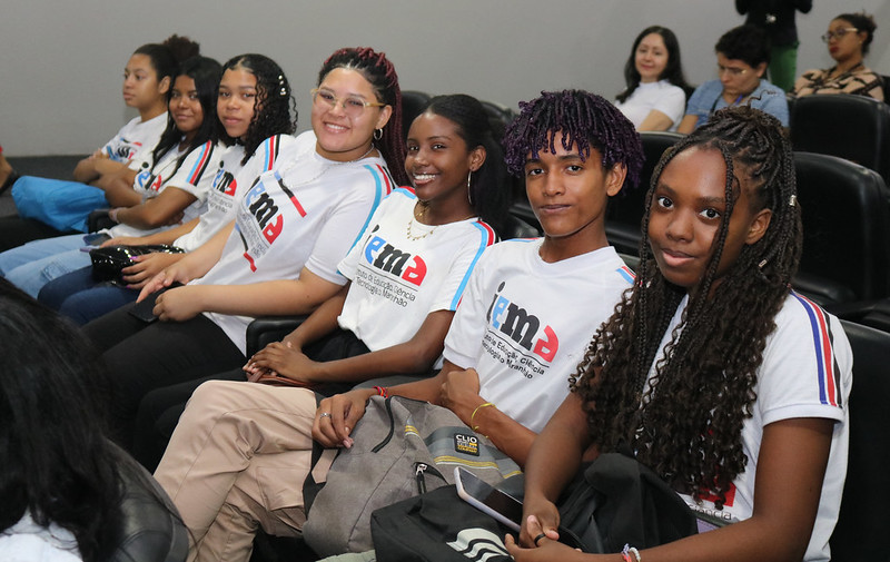 Foto colorida mostra estudantes do IEMA sentados em auditório do Fórum de São Luís durante Seminário de Antidiscrimnação.