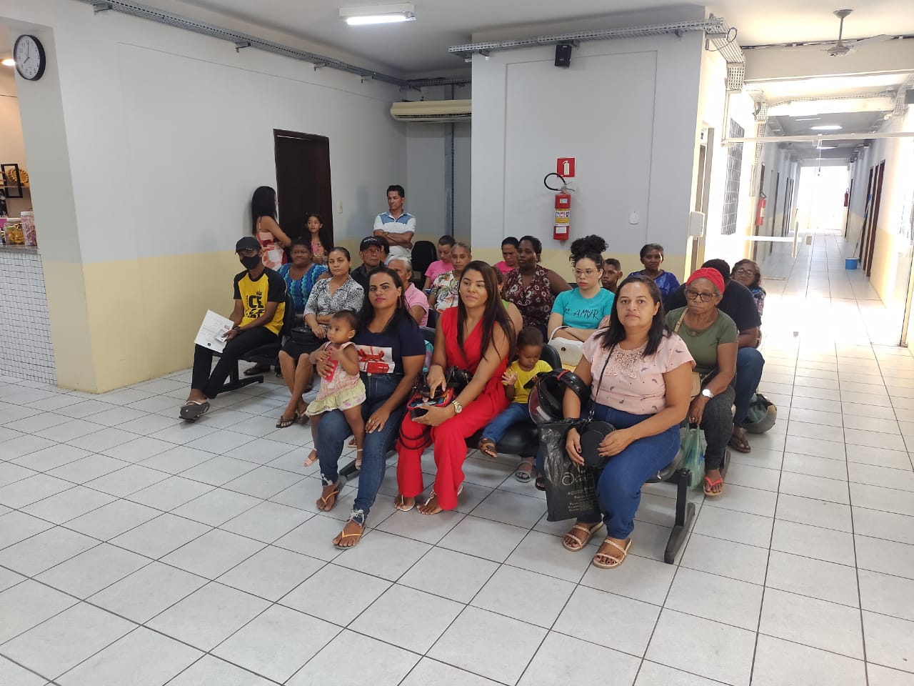 Foto colorida mostra pessoas sentadas em uma sala aguardando serem atendidas por servidoras da Justiça durante projeto Registro Cidadão em Timon.