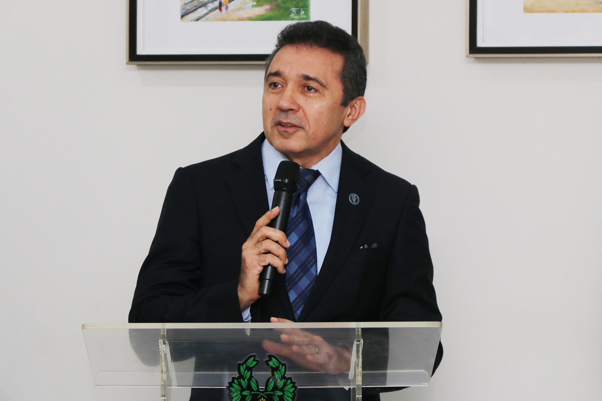 A imagem mostra um ambiente interno, provavelmente um escritório ou local de atendimento, onde três mulheres estão presentes.