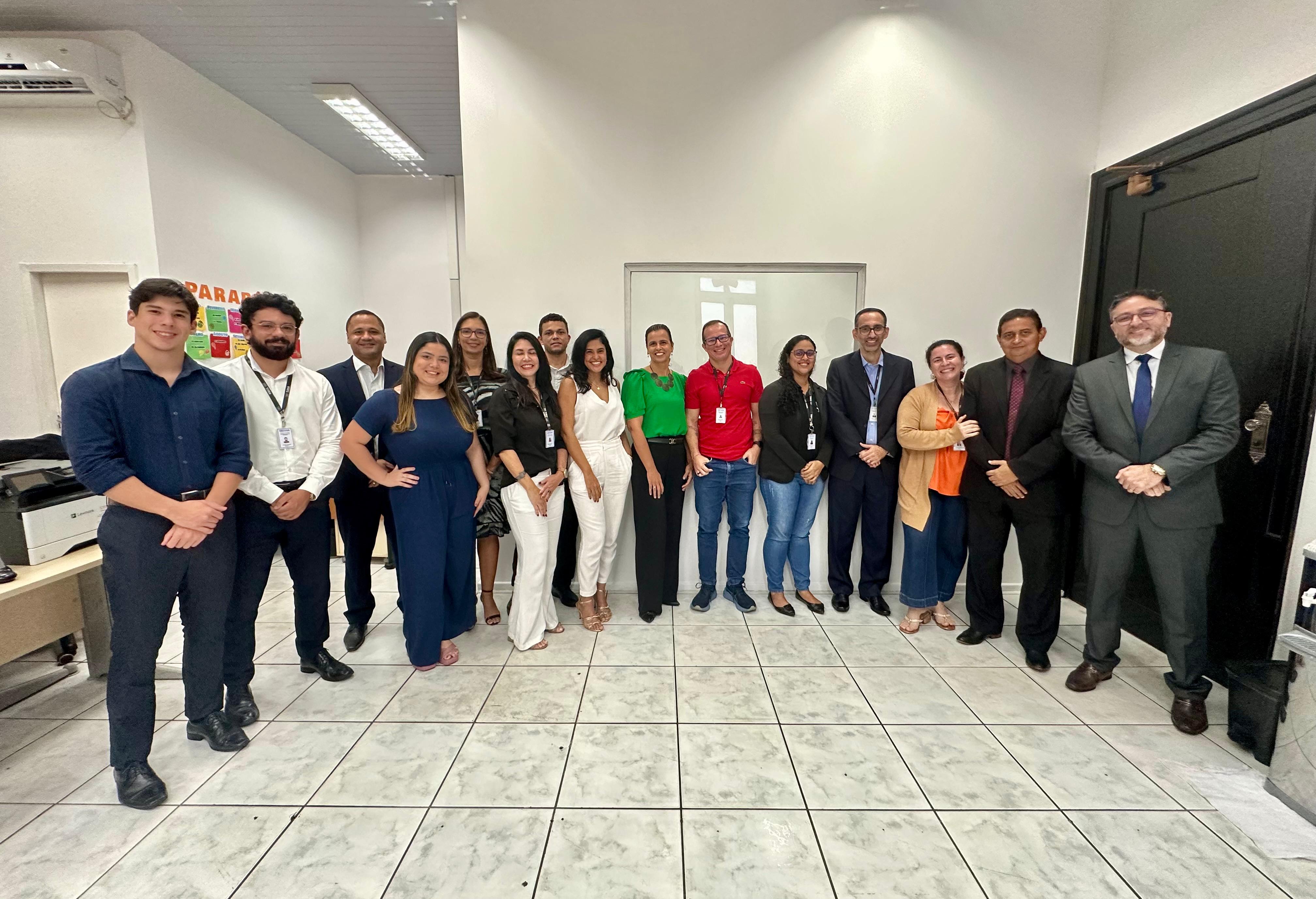 Foto colorida mostra várias pessoas em pé no Gabinete da Presidência do TJMA.