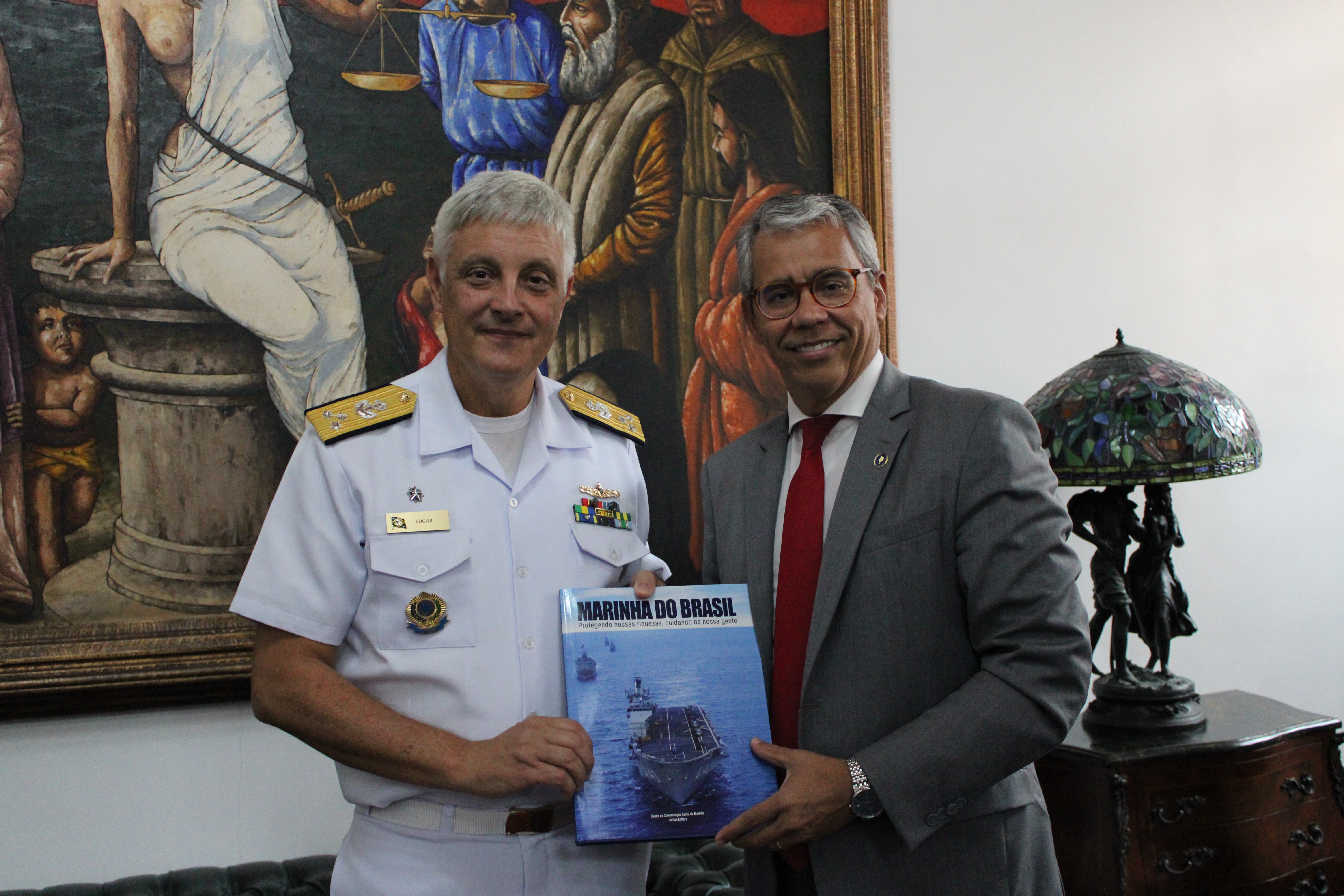 O presidente do TJMA recebendo o livro da Marinha