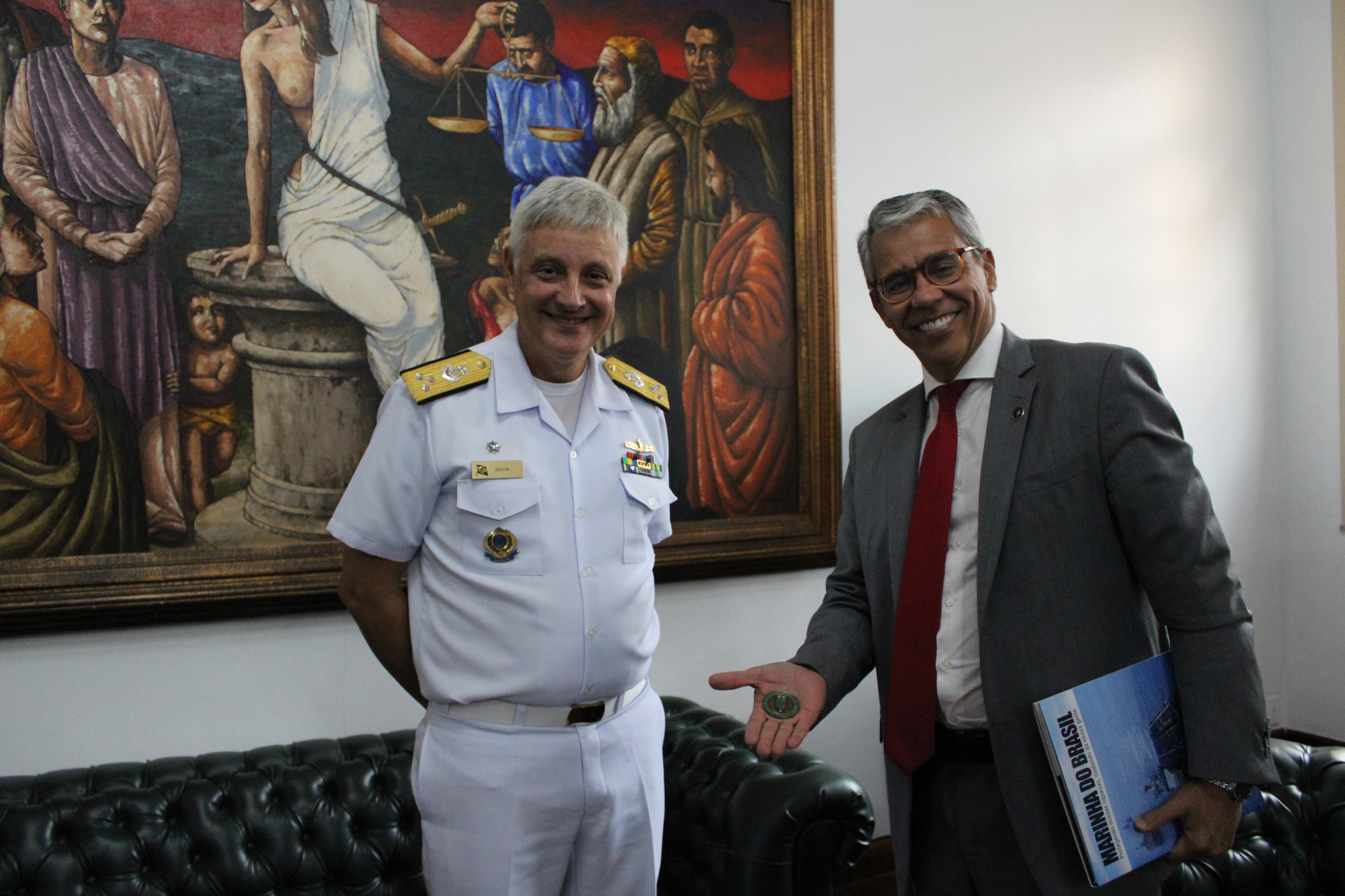 Presidente com a medalha na mão sorrindo, ao lado do vice-almirante de farda