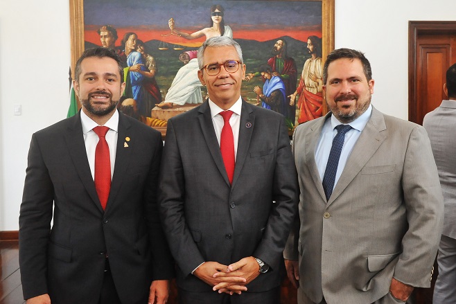 Foto colorida. O presidente da OAB, Kaio Saraiva; o presidente do TJMA, desembargador Paulo Velten e o defensor-geral Gabriel Furtado posam para foto.