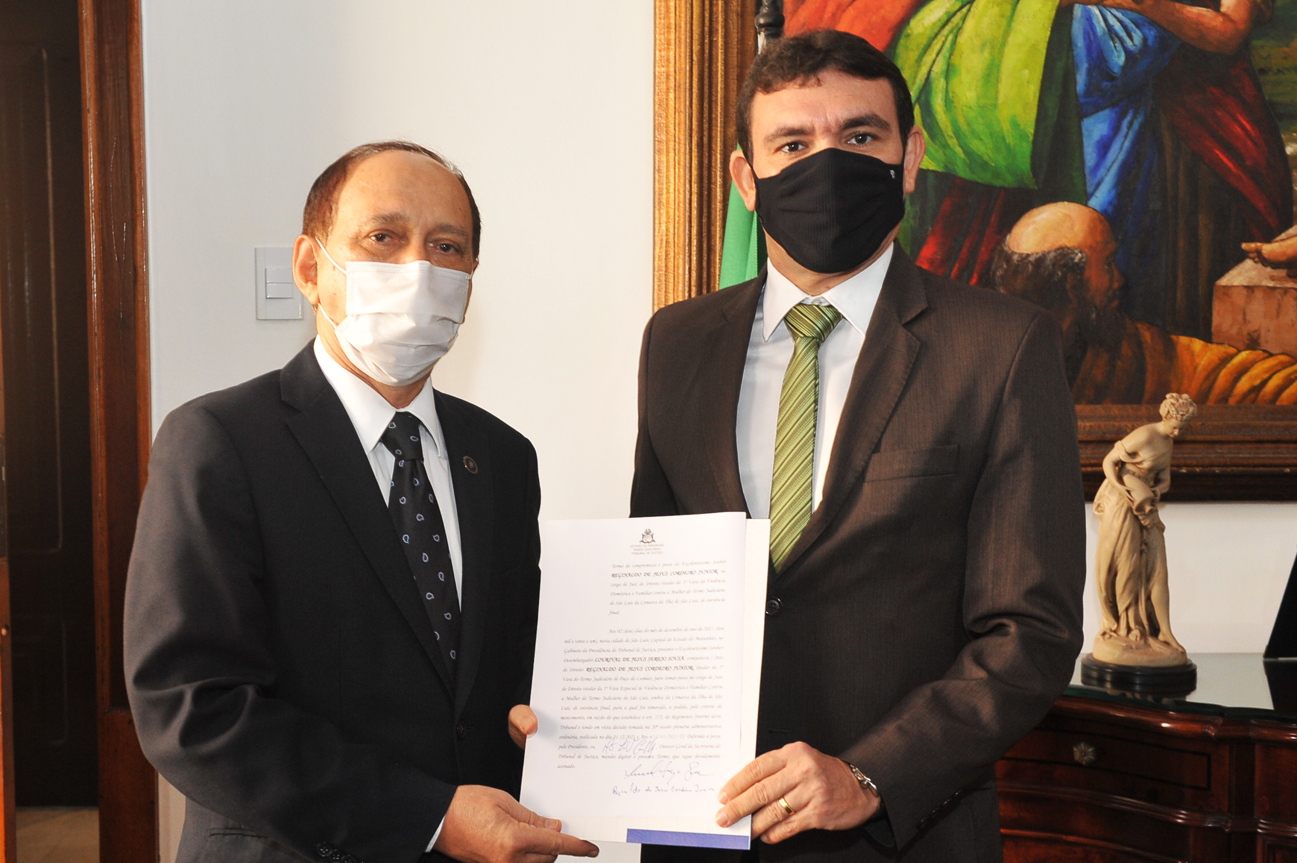 Foto colorida do presidente do TJMA, desembargador Lourival Serejo entregando o Termo de Compromisso e Posse nas mãos do juiz empossado.