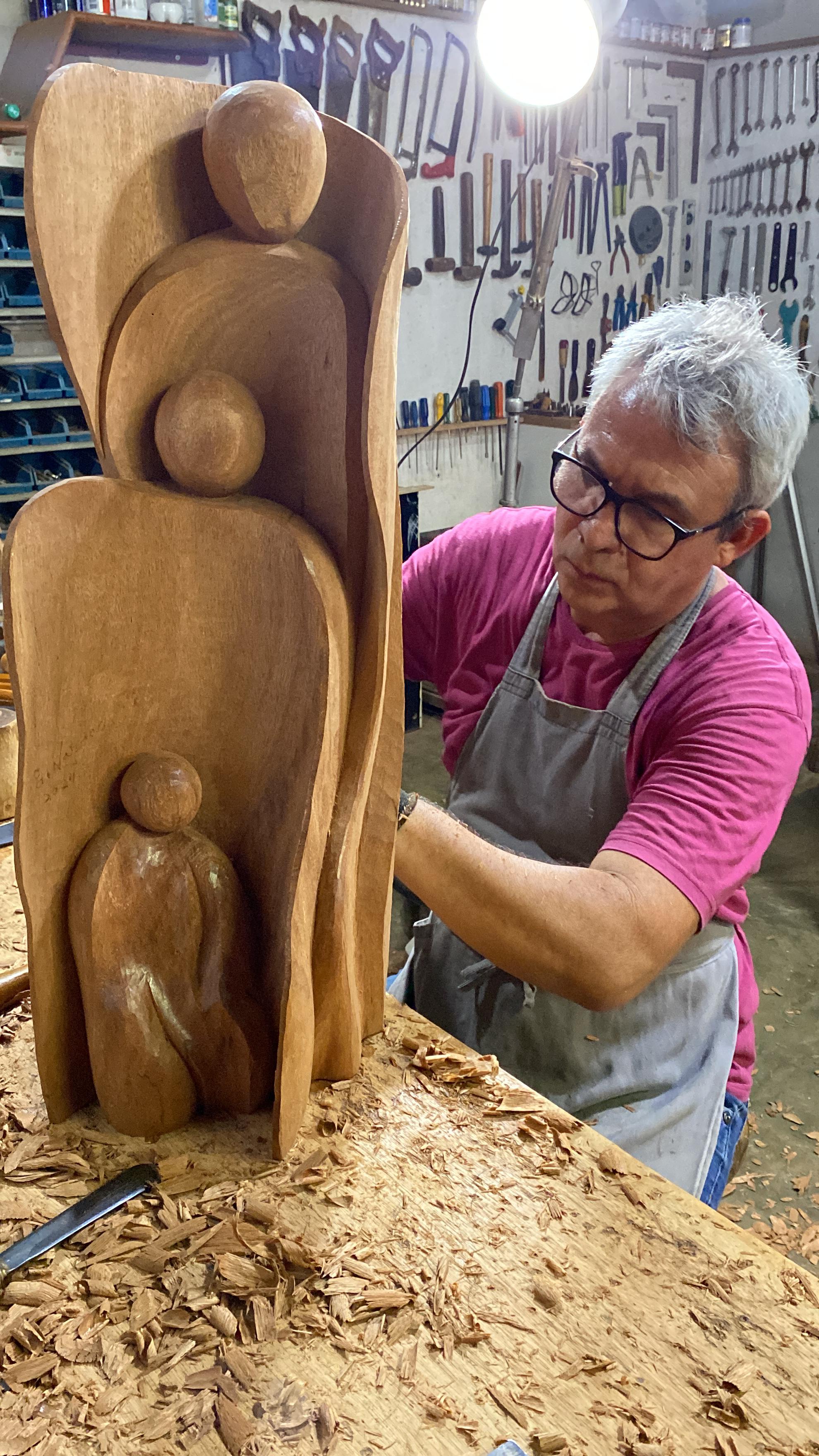 Homem de pé trabalha manualmente na medeira