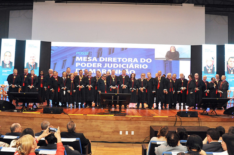 Grupo de desembargadores e desembargadoras do TJMA em pé, lado a lado, vestindo togas pretas, durante posse da mesa diretora para o bienio 2024/2026