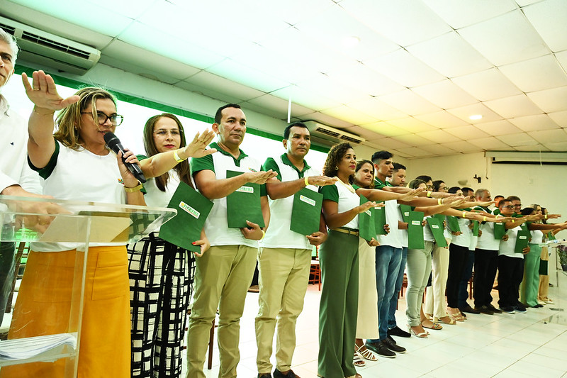 Em palco de auditório, presidente eleita e dirigentes sindicais prestam juramento com mãos à frente durante a posse da nova mesa diretoria da Fetaema