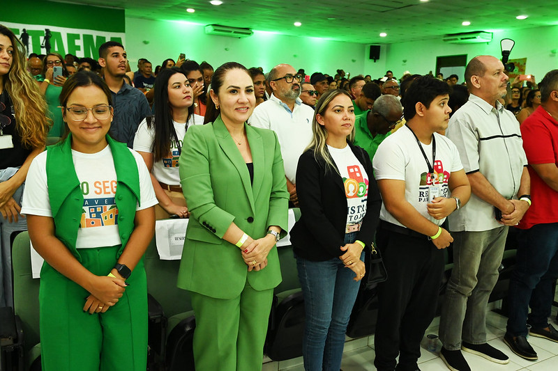 Em auditório, pessoas aparecem em pé em frente às cadeiras, durante solenidade. em destaque, a juíza Ariana Saraiva e servidores(as) do Núcleo de Governança Fundiária do TJMA