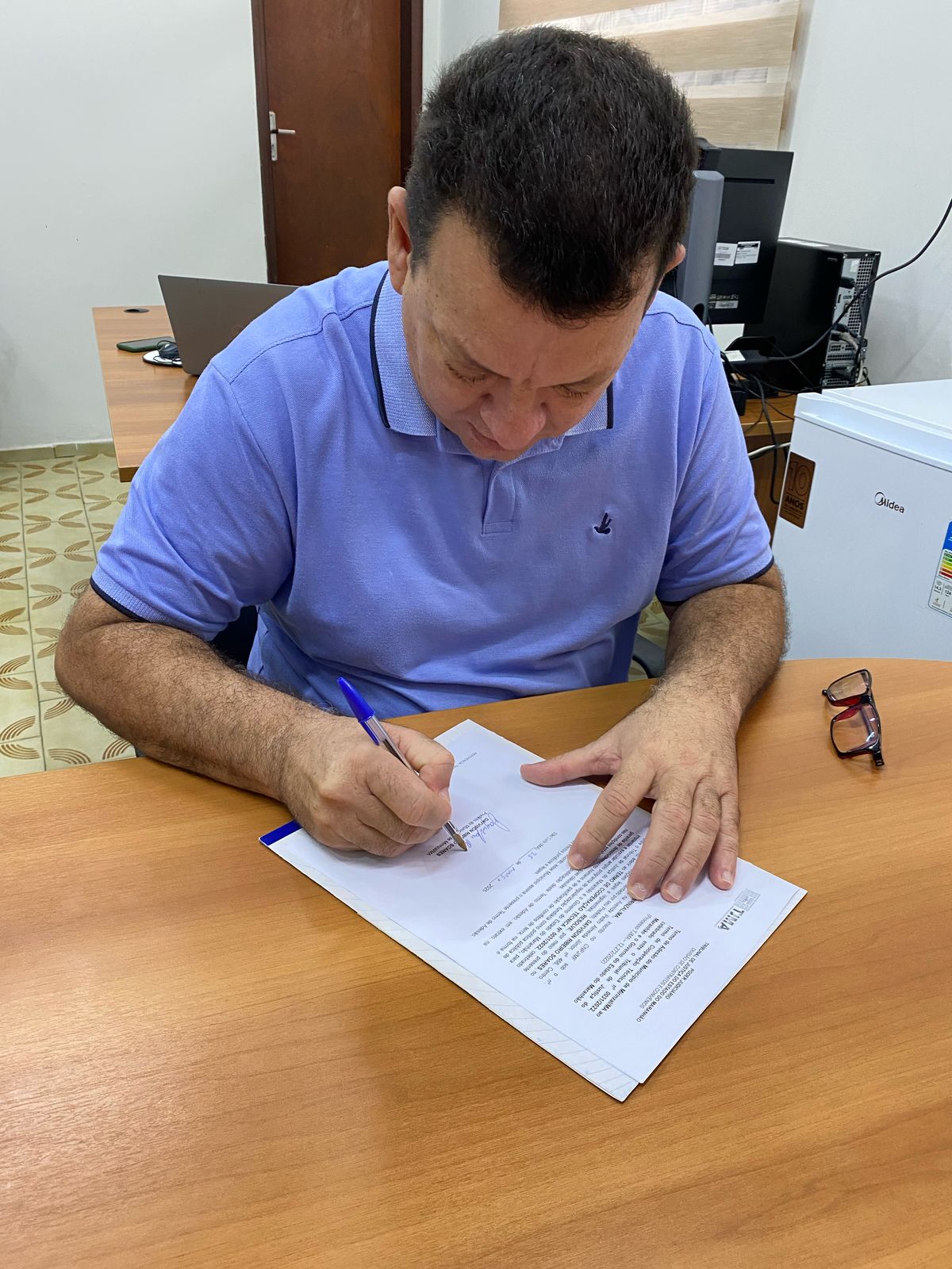 Homem sentado assinado documento