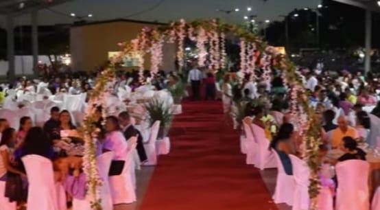 imagem na qual aparece um salão grande  enfeitado  durante a realização de um evento