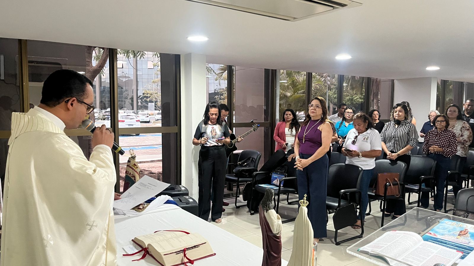 A IMAGEM MOSTRA UM PADRE EM UMA MISSA NO SALA DE REUNIÕES DO FÓRUM SARNEY COSTA.