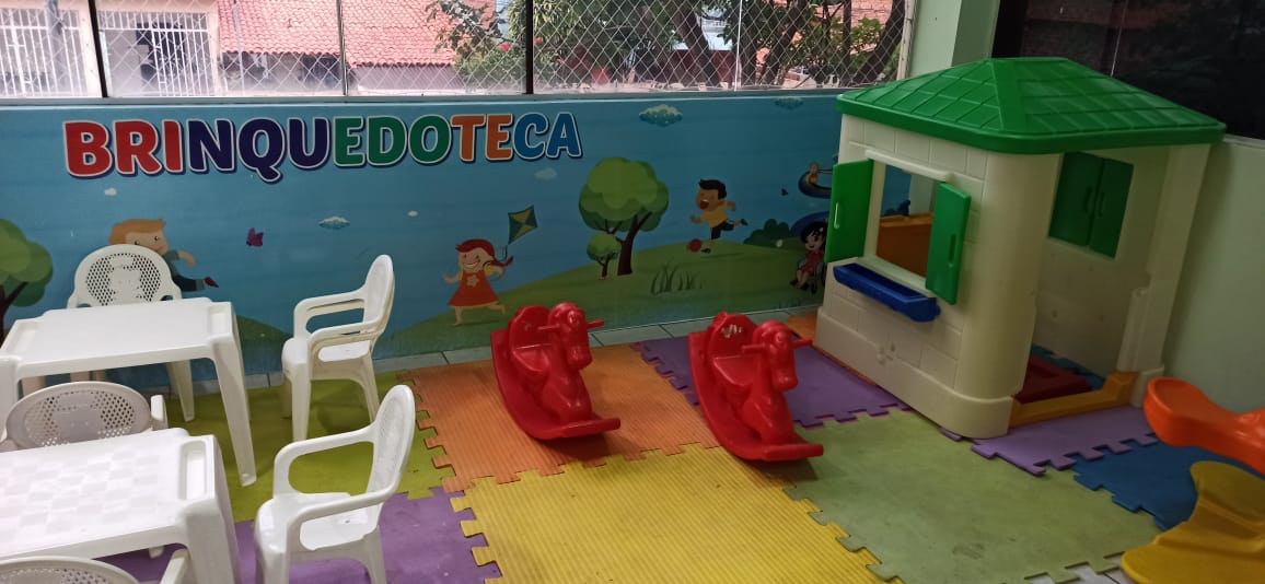 Sala de brinquedoteca forrada de tatame de borracha com móveis coloridos adaptados para crianças