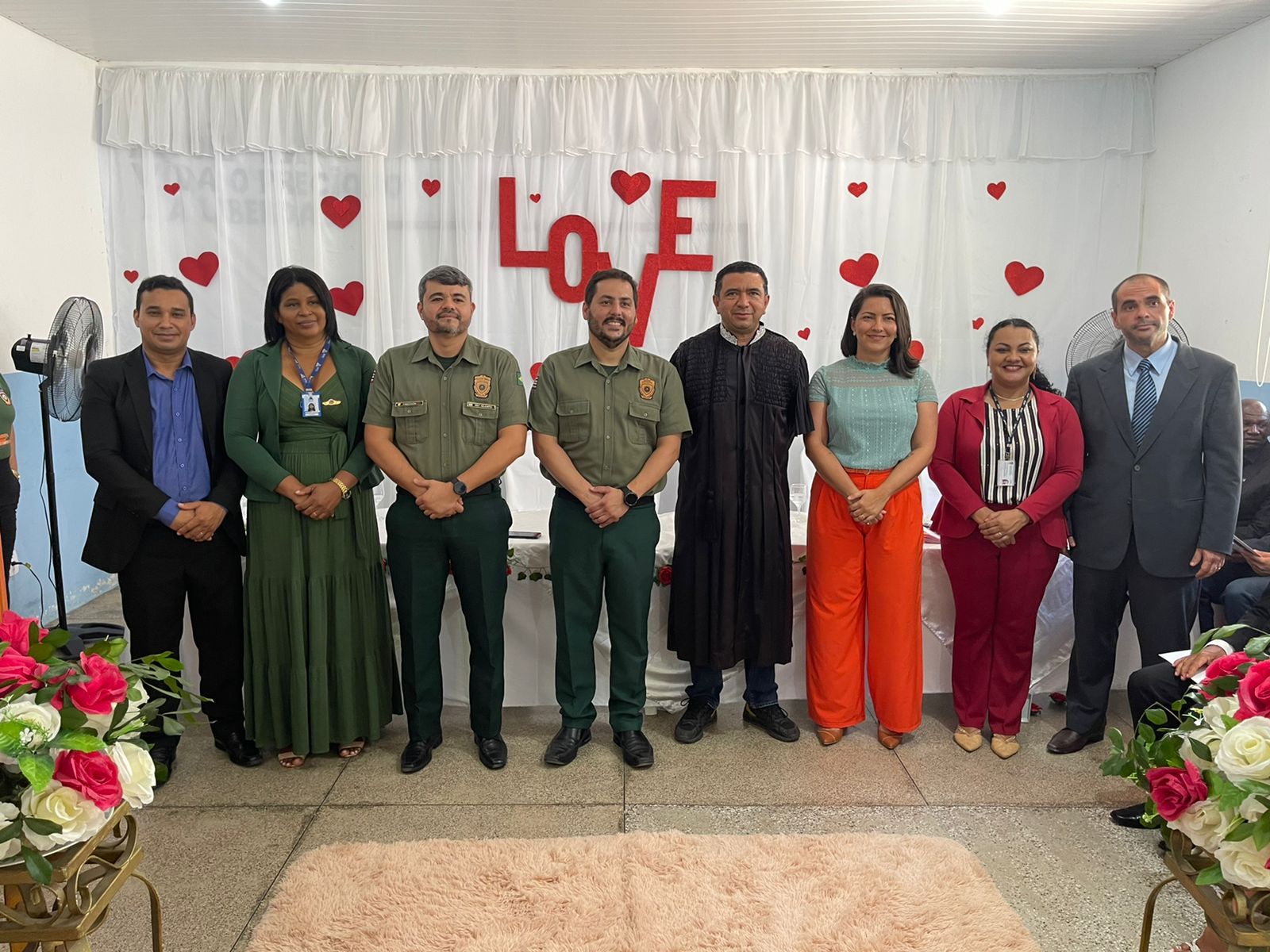 Homens e mulheres posam pra foto diante de cortina branca com nome "love".