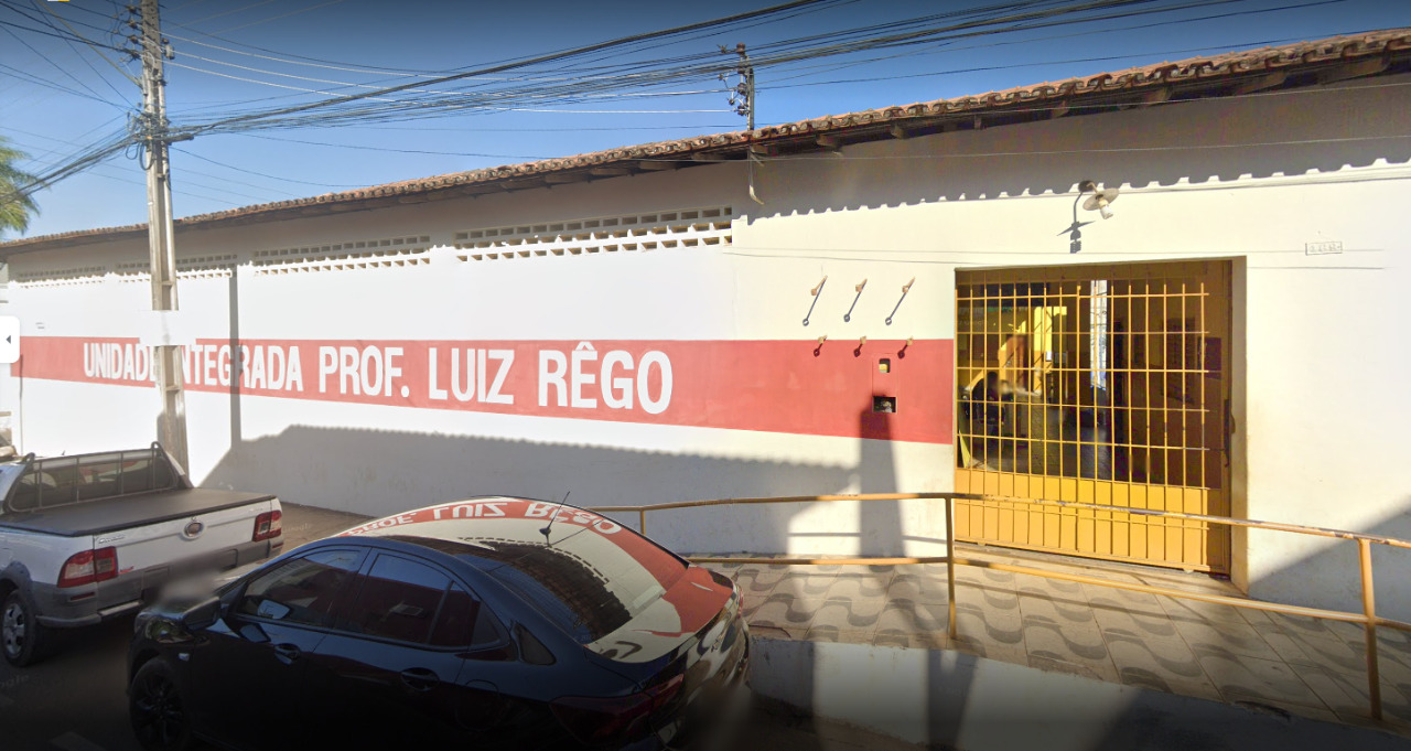 Fachada de escola nas cores amarela com nome branco: Unidade Integrada Professor Luis Rego.