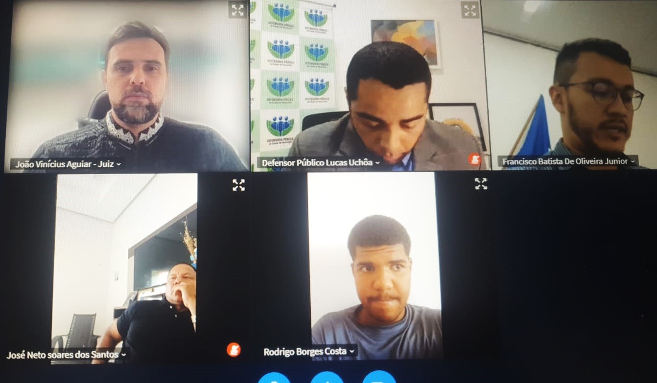 Foto de tela de computador com 4 homens participando de audiência judicial.