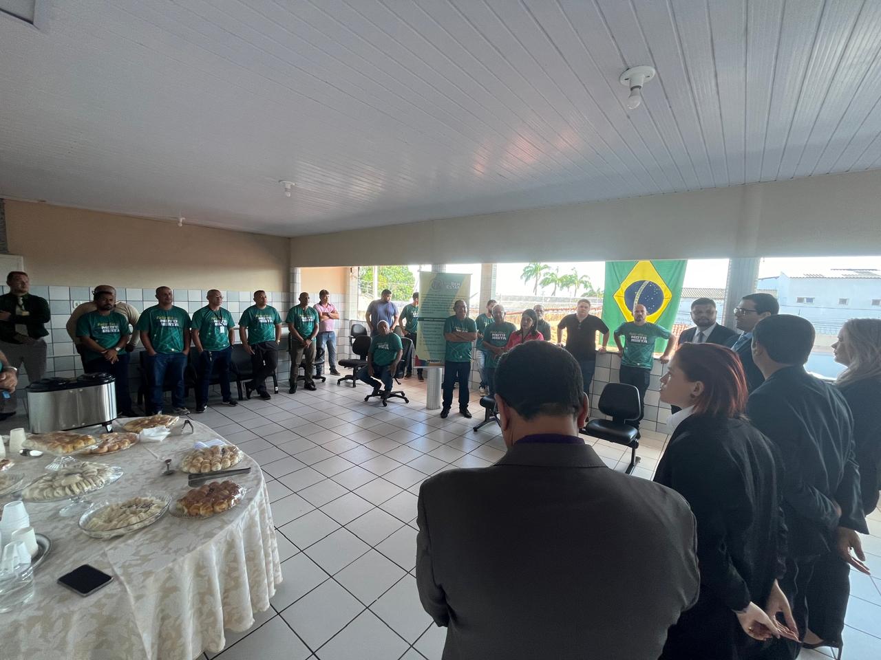TODOS ESTÃO REUNIDOS EM CIRCULOS. NO MEIO ESTÁ A MESA COM O CAFÉ DA MANHÃ.