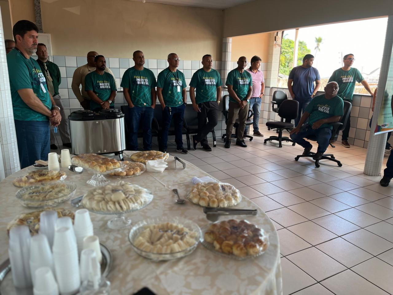 PESSOAS ESTÃO REUNIDAS EM VOLTA DE UMA GRANDE MESA COM UM CAFÉ DA MANHÃ.