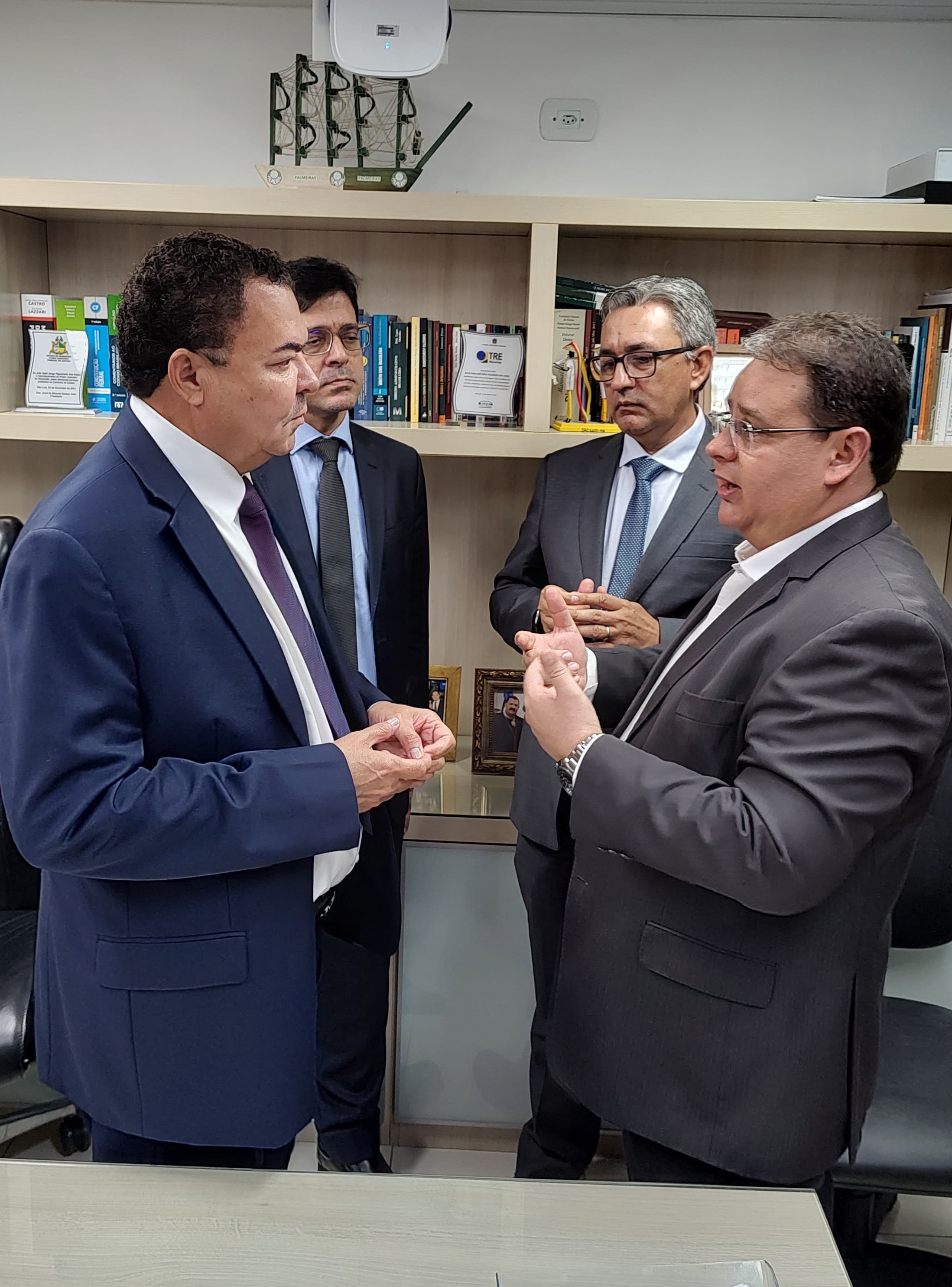 foto mostra desembargador josé jorge conversando com o cartorário cristian, sendo observados pelo juiz andrea bogea e cartorário devanir garcia.