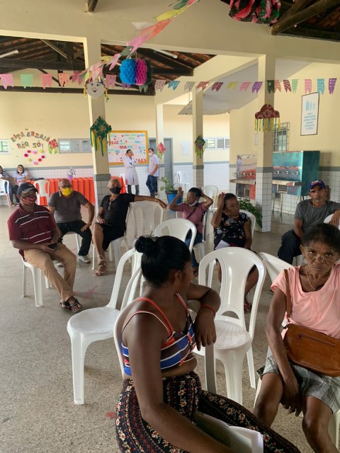 Foto colorida mostra pessoas sentadas em local de atendimento do projeto Conciliação Itinerante em Coroatá.