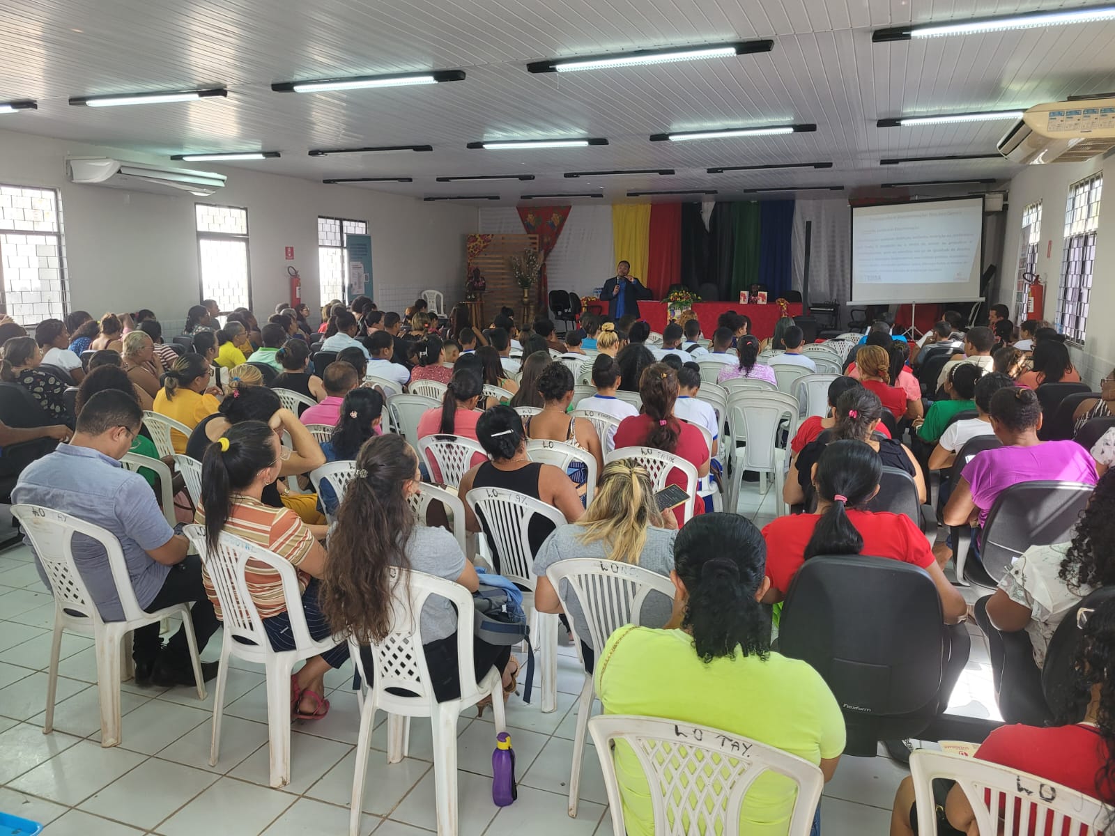 Foto colorida. Pessoas sentadas durante palestra do juiz Marco Adriano, em São Luiz Gonzaga, durante ação itinerante do Comitê de Diversidade.