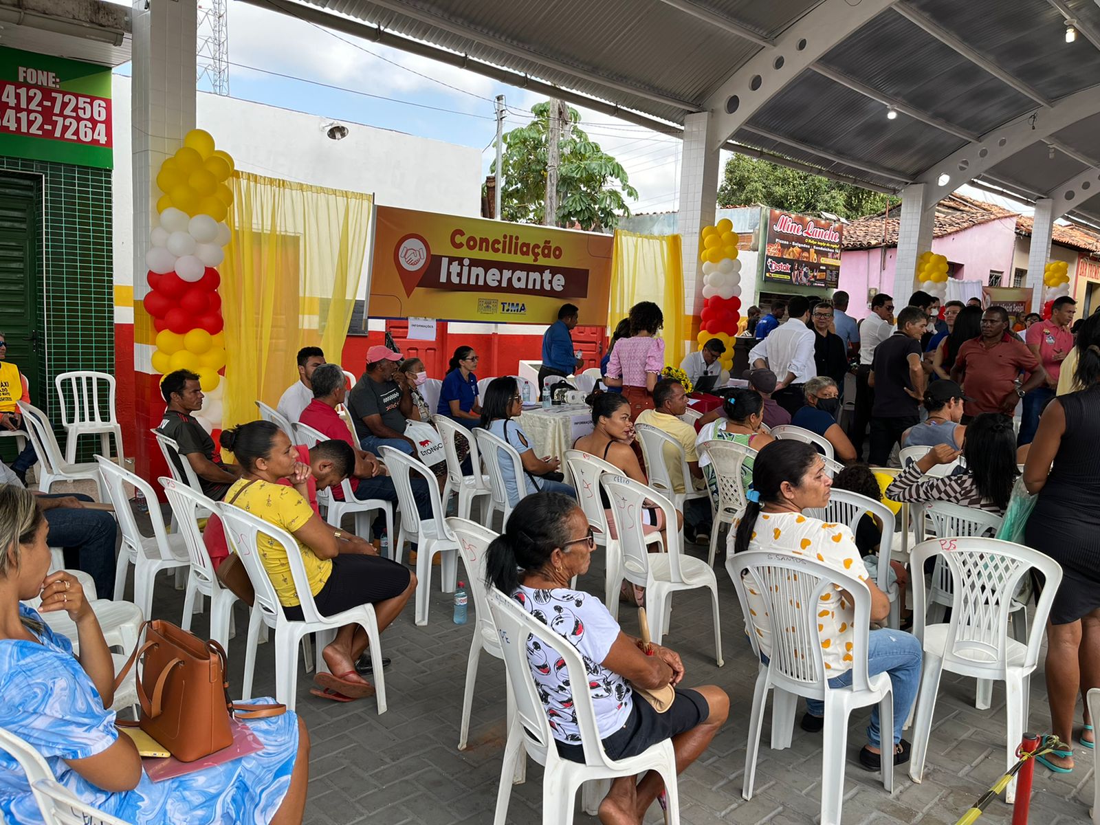 Foto colorida de pessoas sentadas, dialogando com conciliadores e conciliadoras, durante projeto Conciliação Itinerante em Passagem Franca