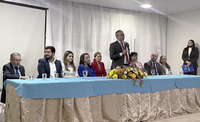 Foto colorida mostra o presidente do TJMA, desembargador Paulo Velten, em pé, durante aula magna na UEMASUL, Campus Açailândia. Os demais integrantes acompanham sentados à mesa.
